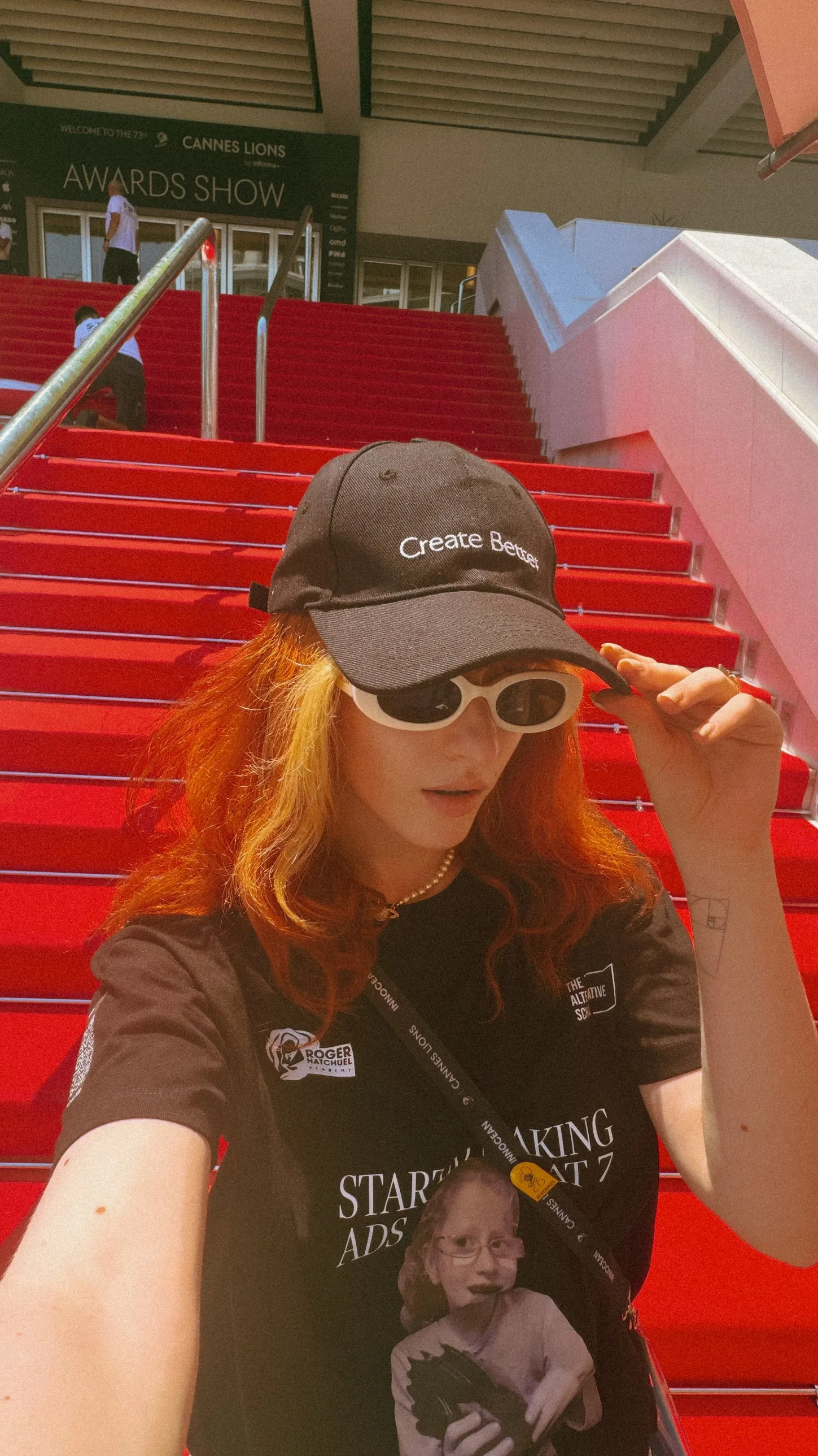 Julieta Calotă on the red stairs wearing a Create Better cap