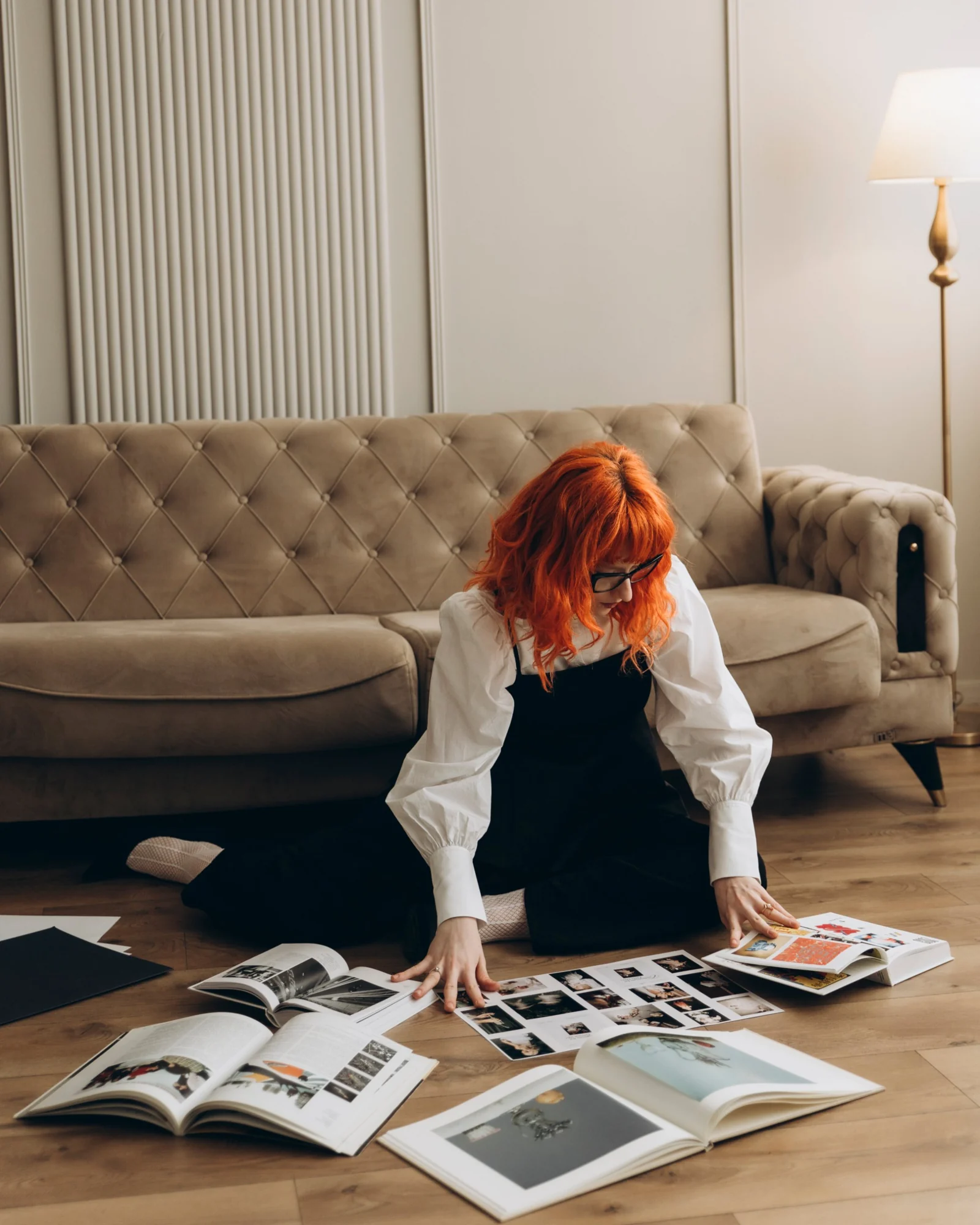 Julieta Calotă on the floor surrounded by open books and printed layouts