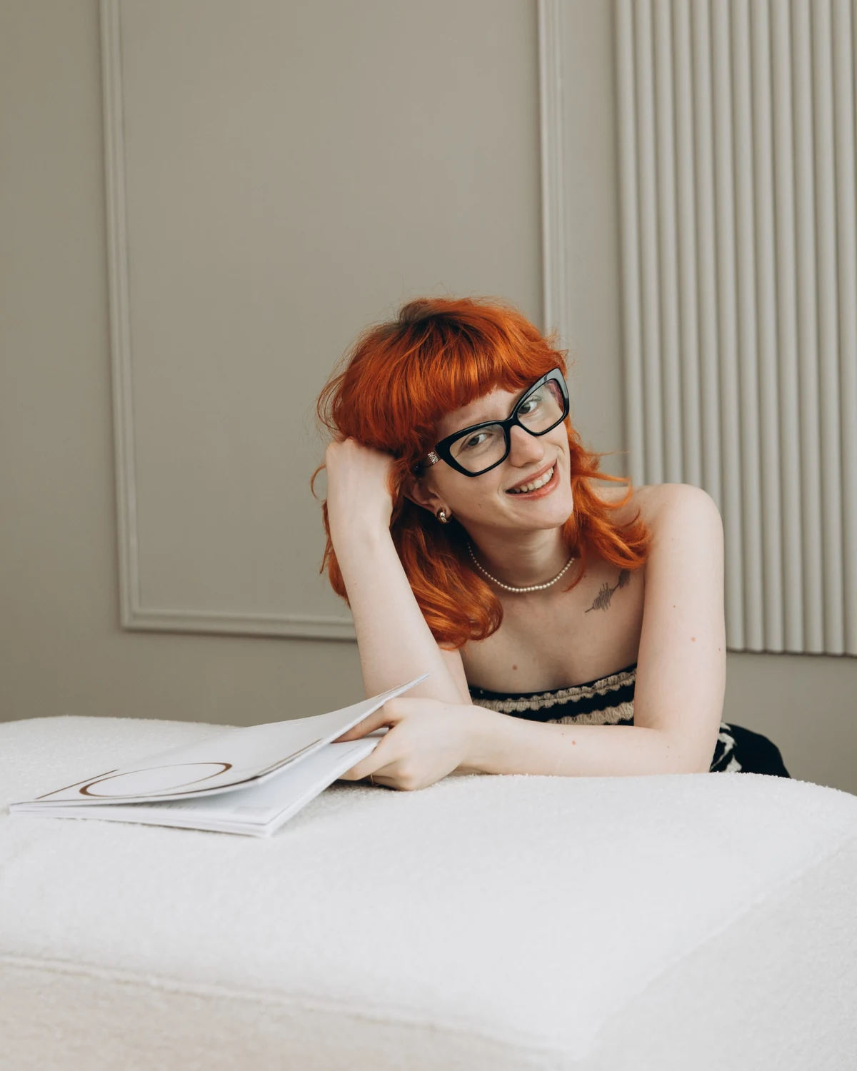 Julieta Calotă, freelance art director, smiling and holding a magazine