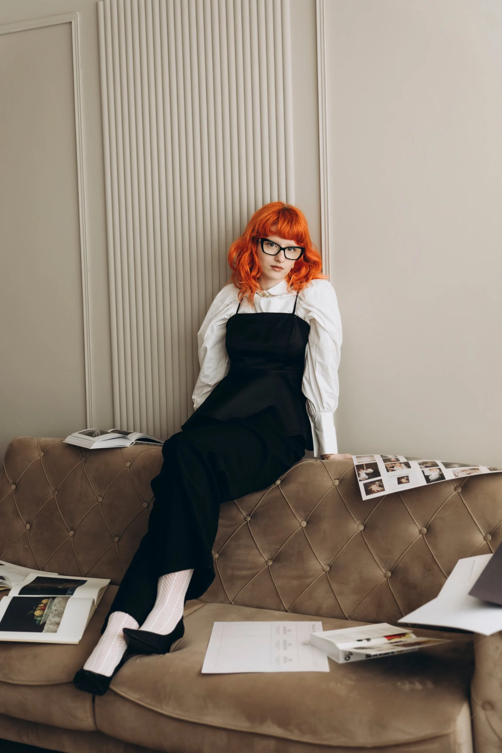 Julieta Calotă sitting on a sofa surrounded by magazines